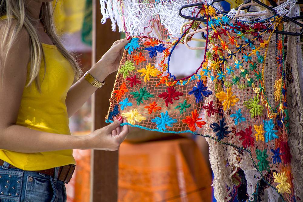 Feiras de artesanato em Maceió - mulher escolhendo peça de filé alagoano
